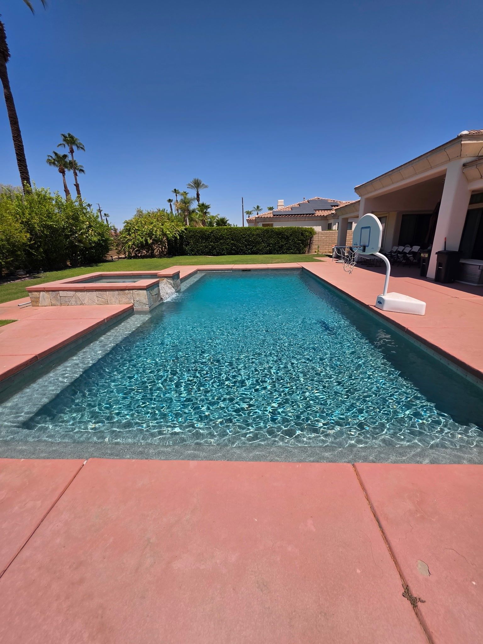 A large swimming pool with a wooden fence surrounding it.