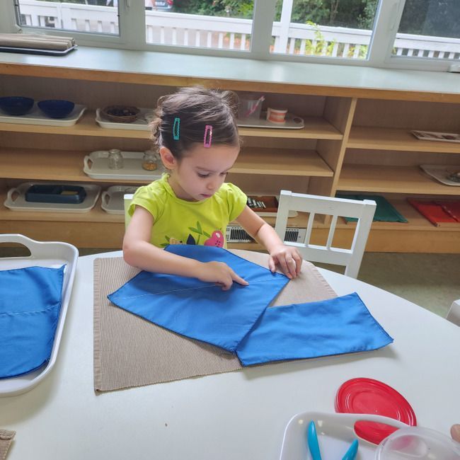 Montessori child folding napkins