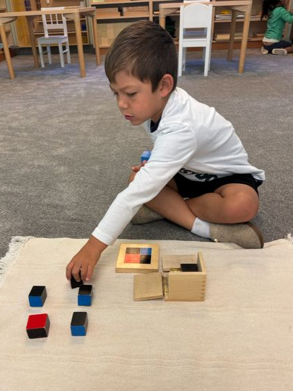 Montessori child working with the Binomial Cube