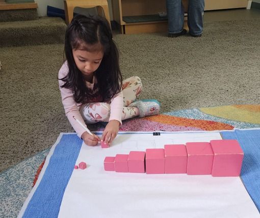 Child working with a Montessori pink tower