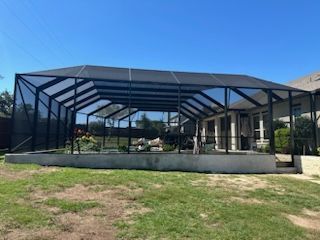Large screened pool cage attached to brick home in Lakeway TX