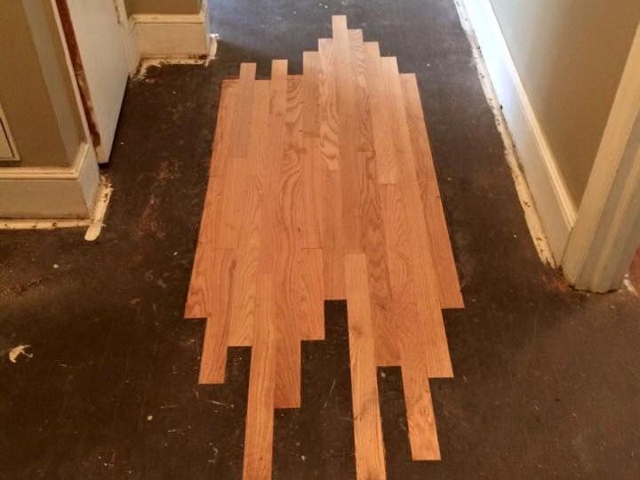 A wooden floor is being installed in a hallway.