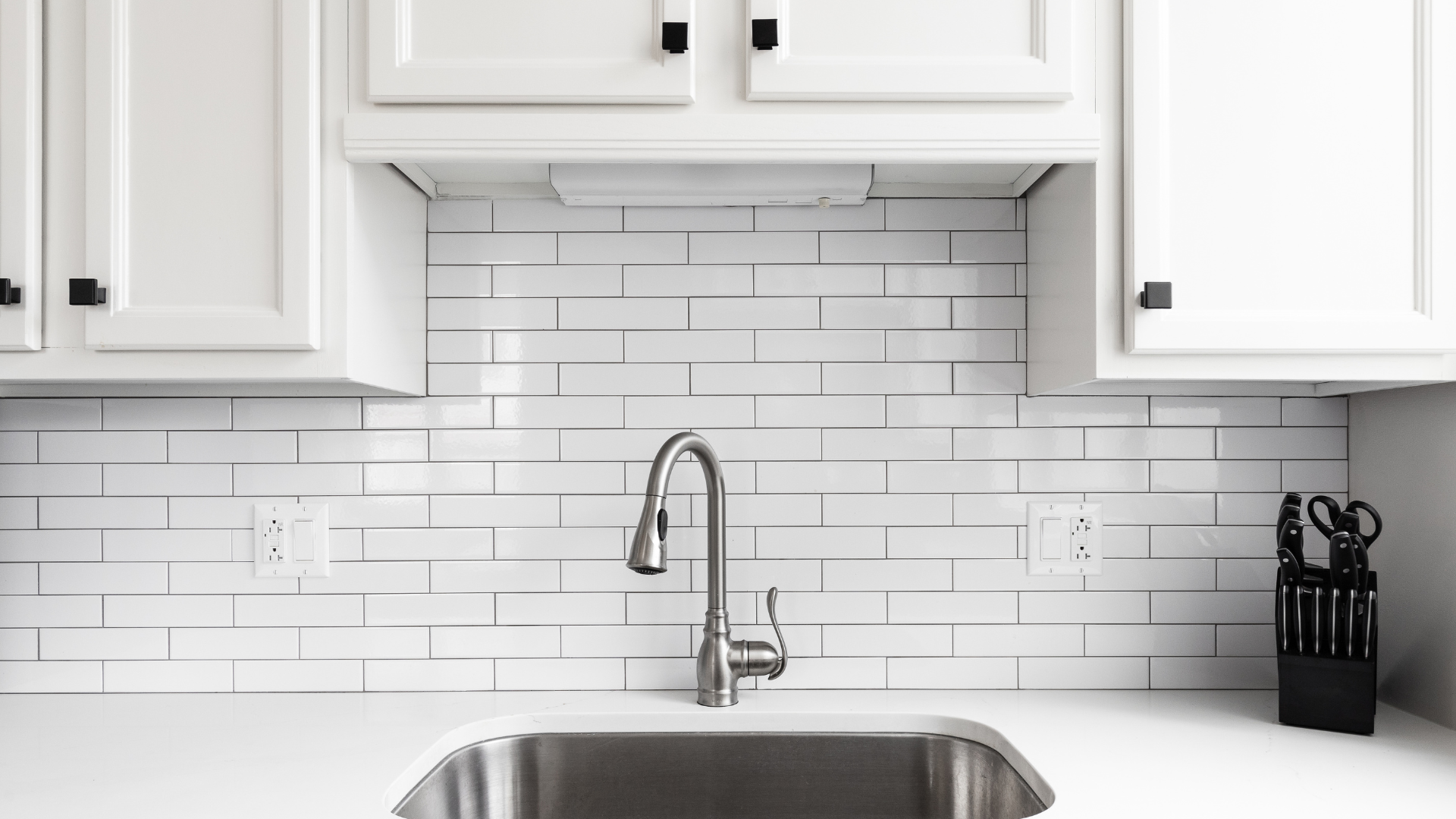 kitchen sink with white subway tile backsplash