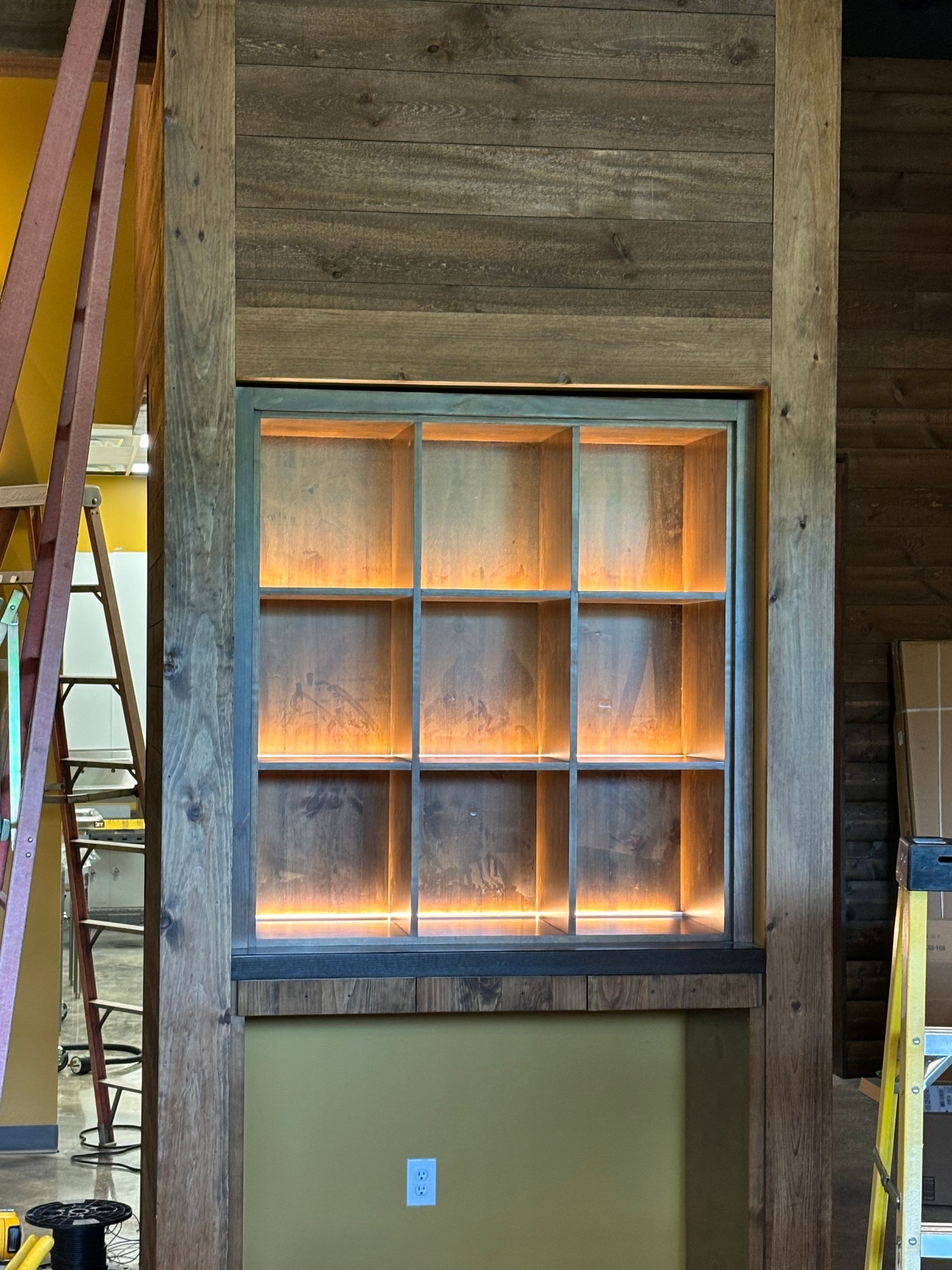 A wooden wall with shelves and a ladder in the background