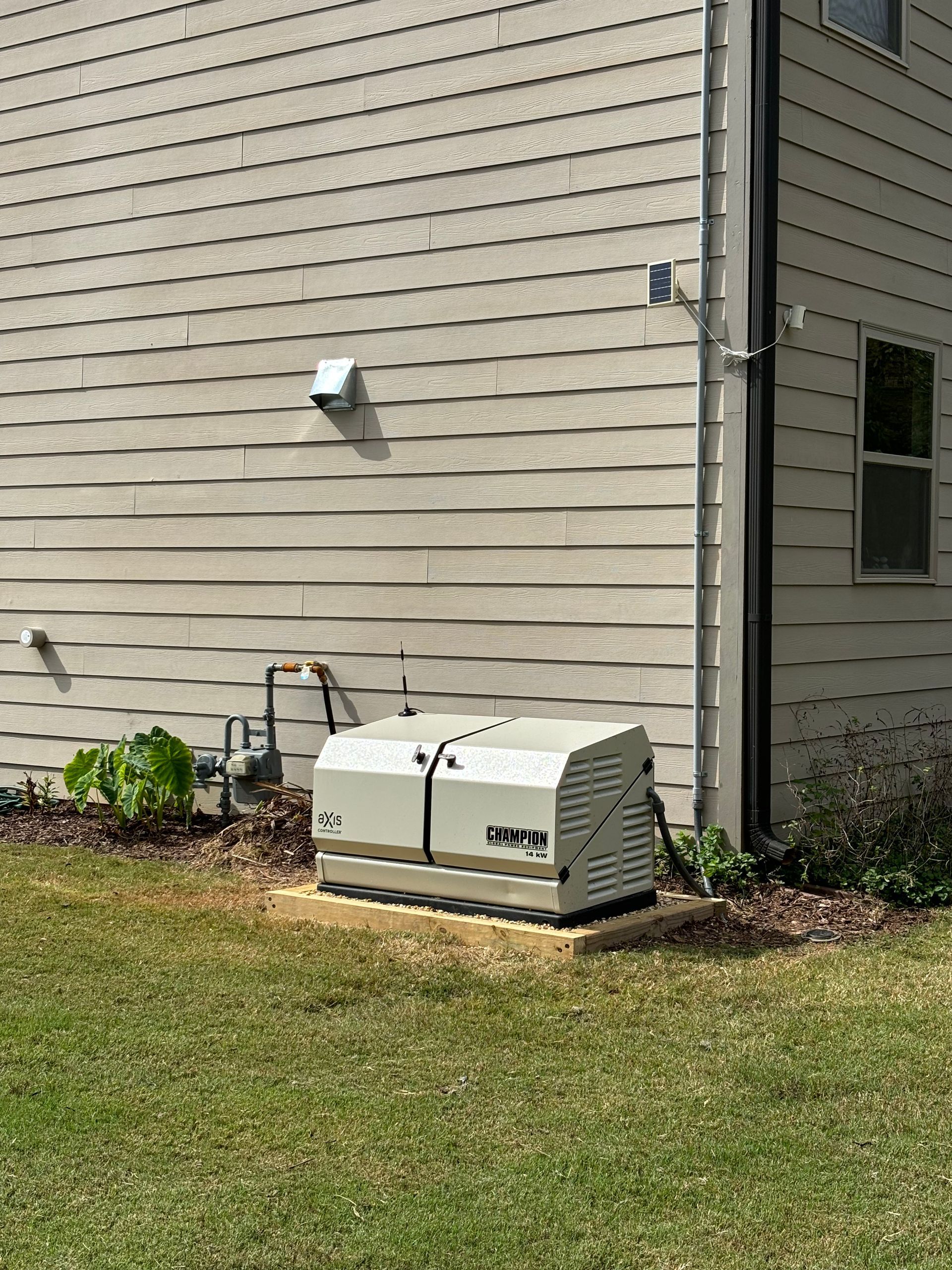 A generator is sitting on the side of a house.