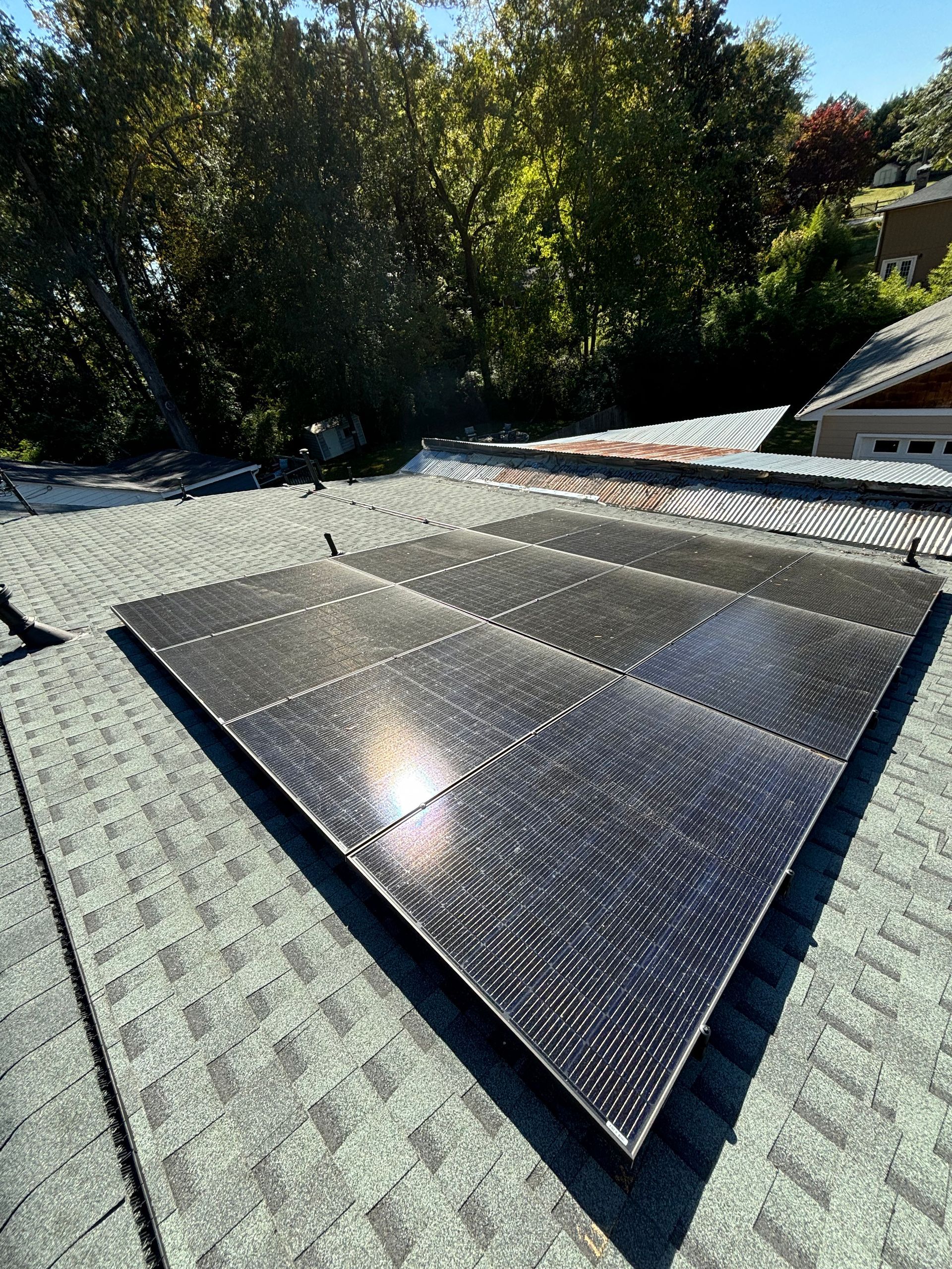 A row of solar panels are sitting on top of a roof.