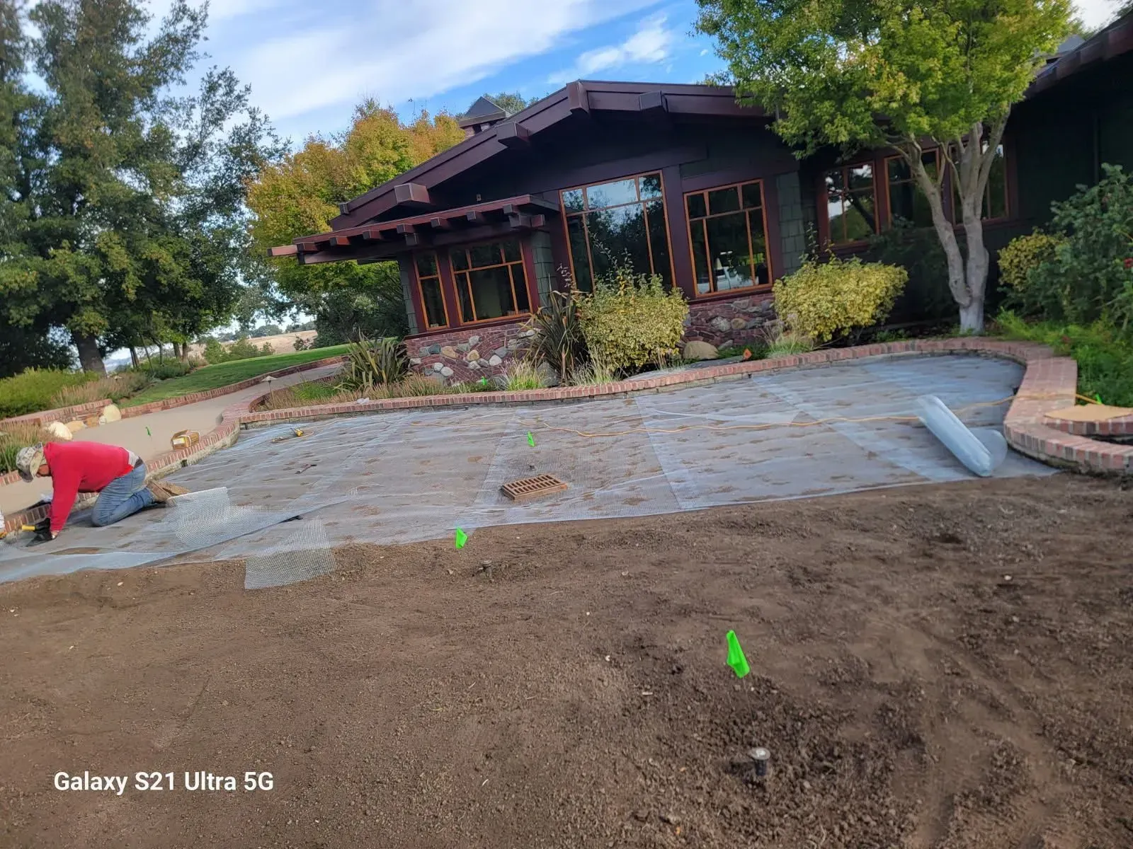 A man is working on a lawn in front of a house.