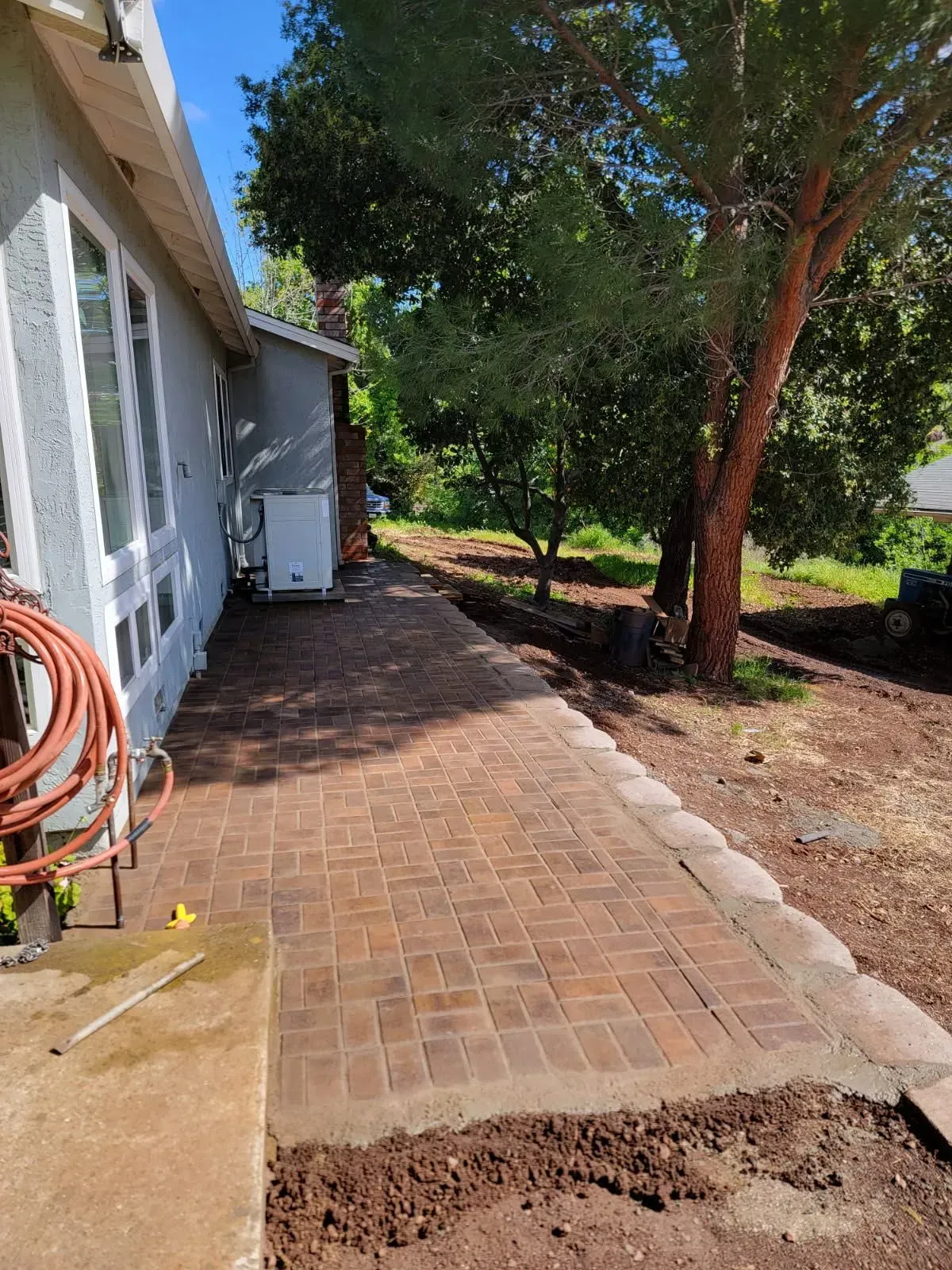 A brick walkway is being built in front of a house.