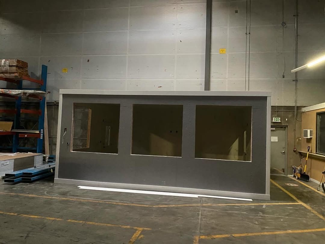 Gray rectangular structure with three openings in a warehouse.