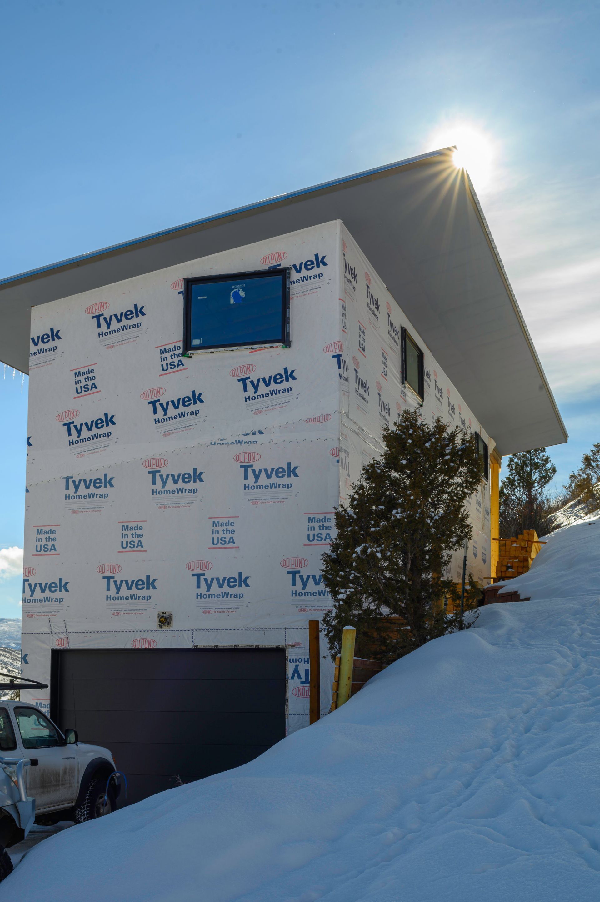 A house is being built on top of a snow covered hill.