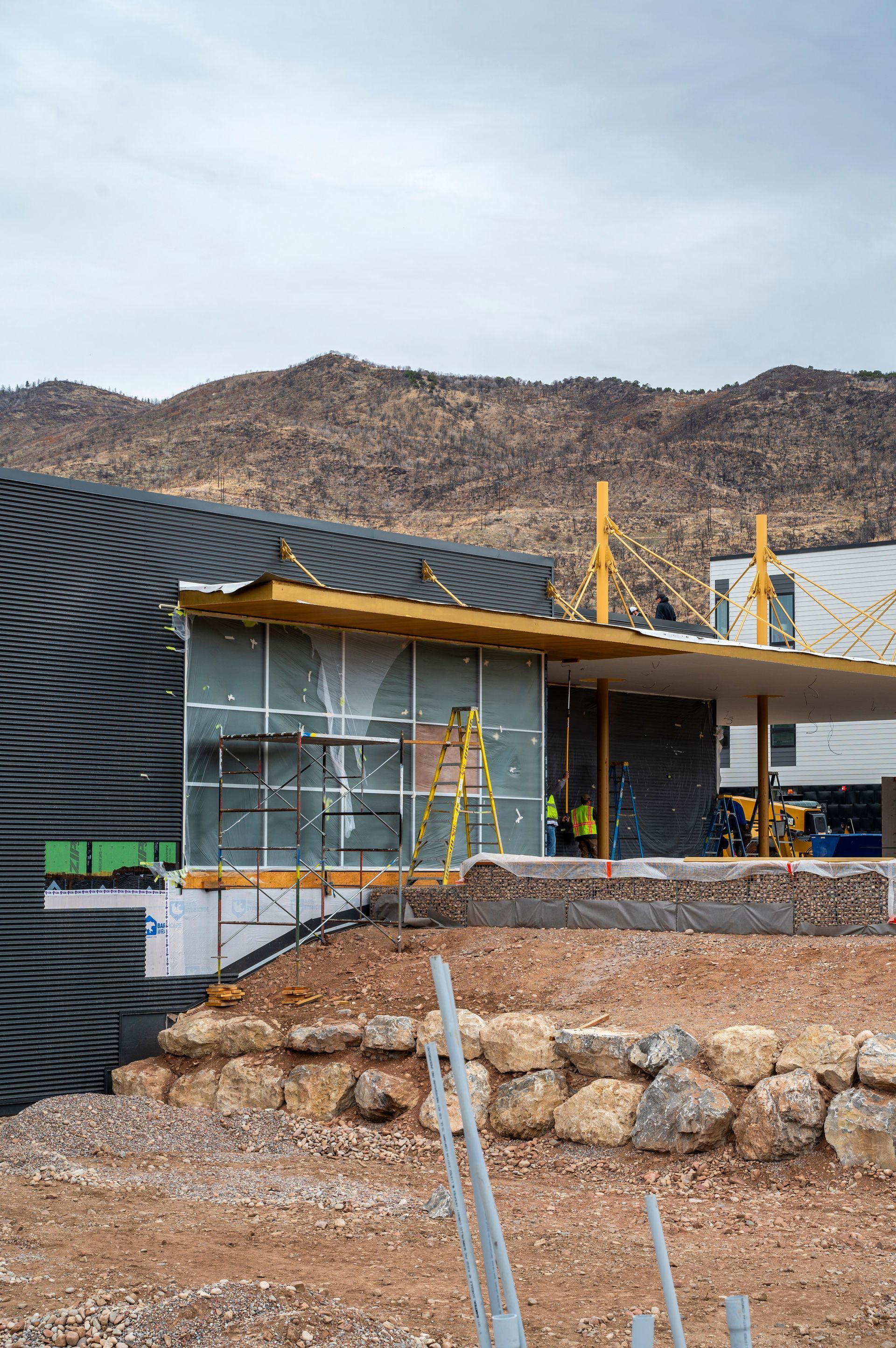 A house is being built in the desert with mountains in the background.