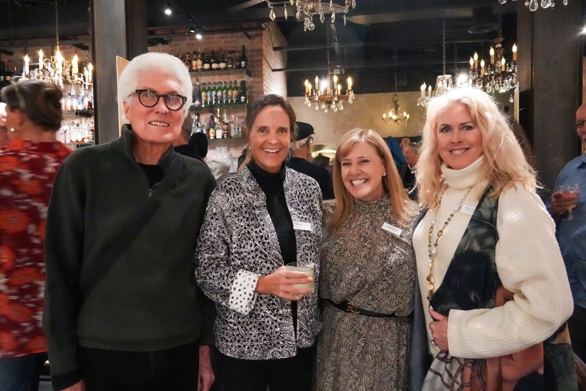 A group of four is posing for a photo inside the event venue.