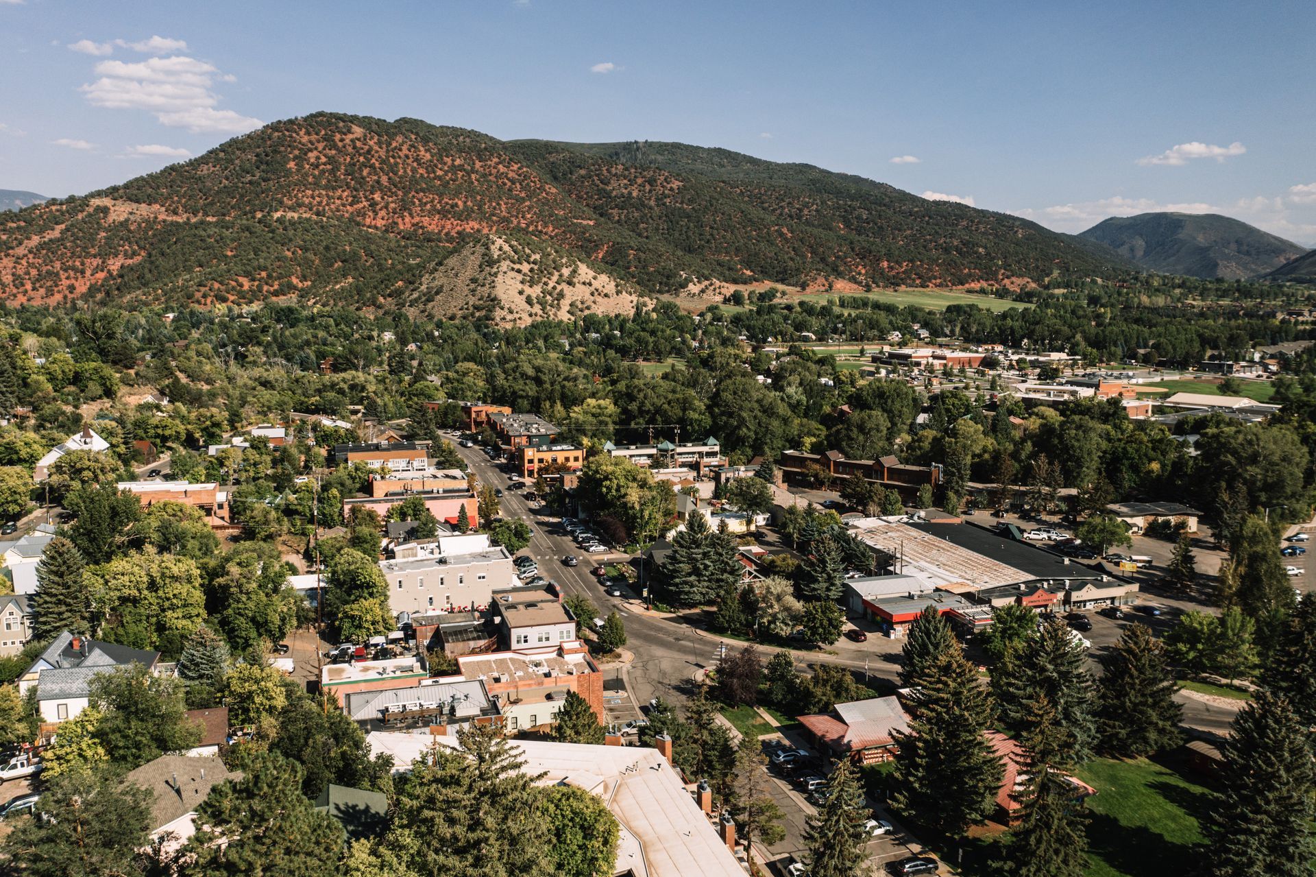 An aerial view of a small town with mountains in the background.