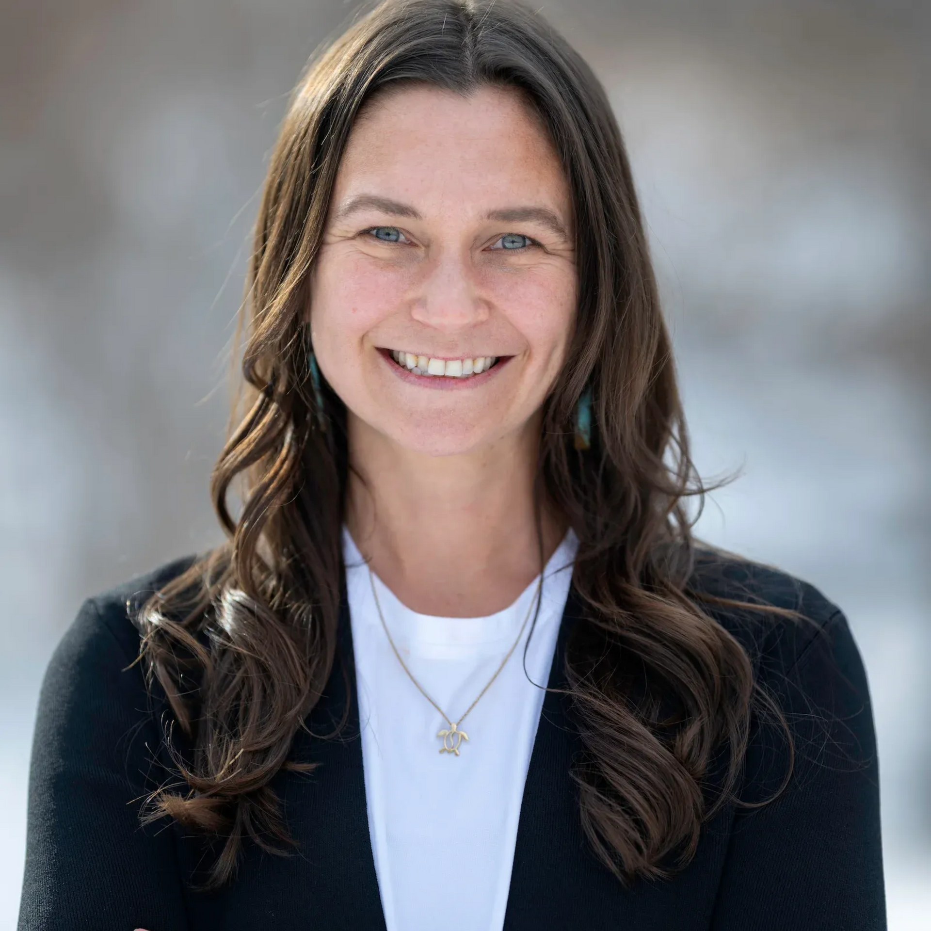 A woman in a green shirt is smiling for the camera.