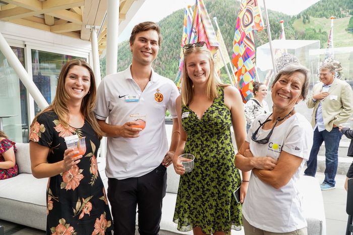 A group of people are posing for a picture while holding drinks.