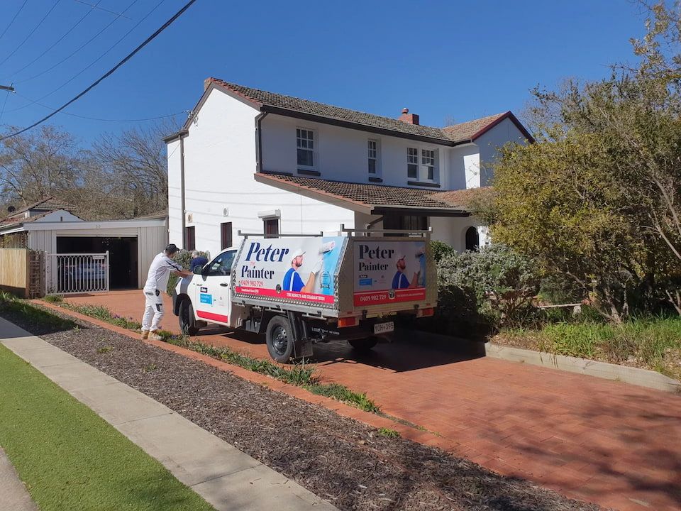 Two Men Painting a Wall With Rollers and Buckets of Paint — Peter the Painter In Evatt, ACT