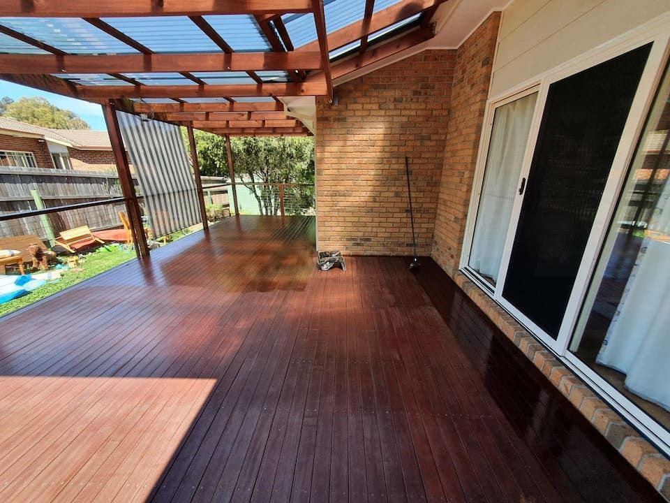Charming Outdoor Space Featuring a Wooden Deck, Brick Wall, and Sliding Glass Door — Peter the Painter In Evatt, ACT