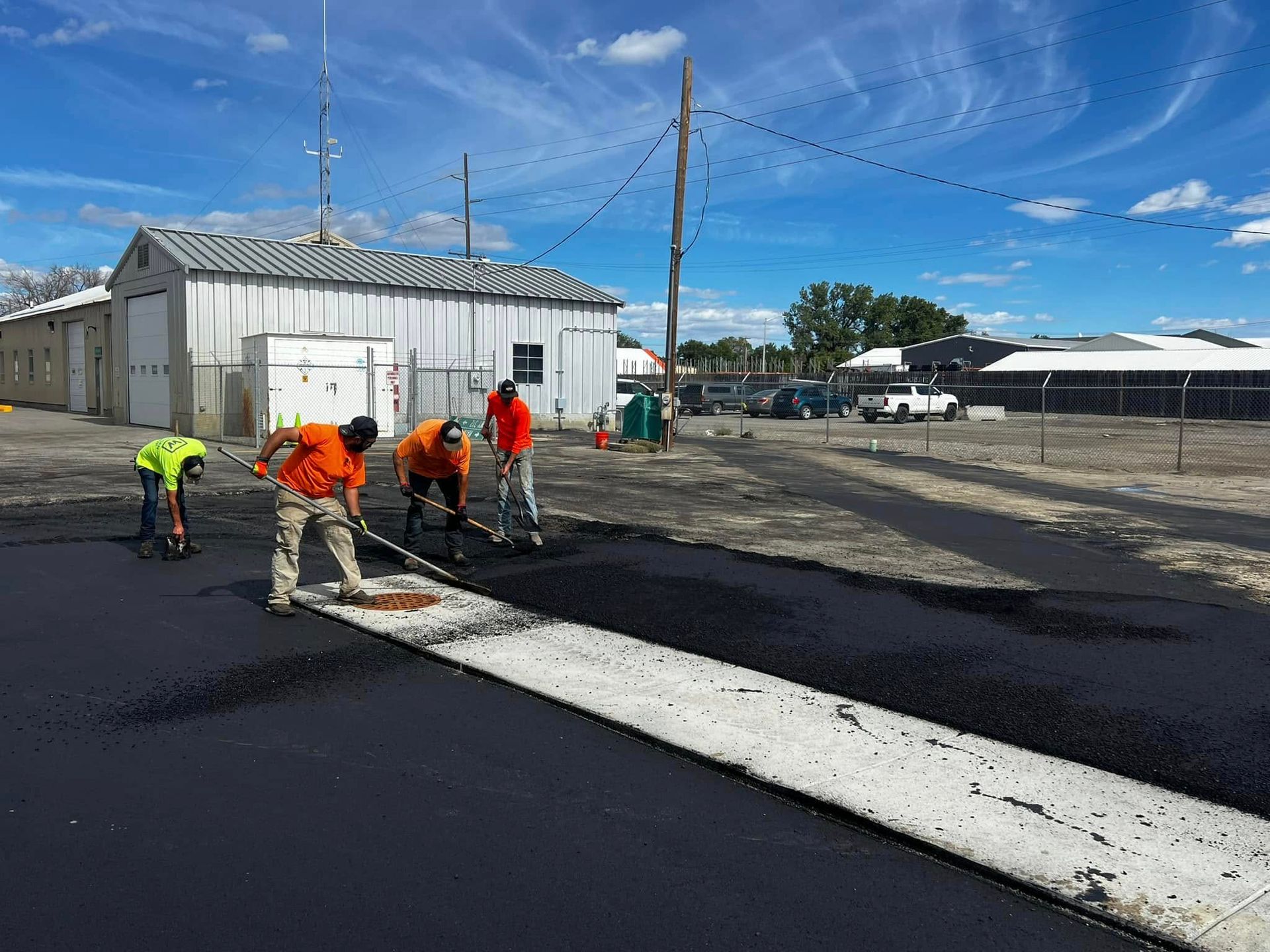 A group of construction workers are working on a road.