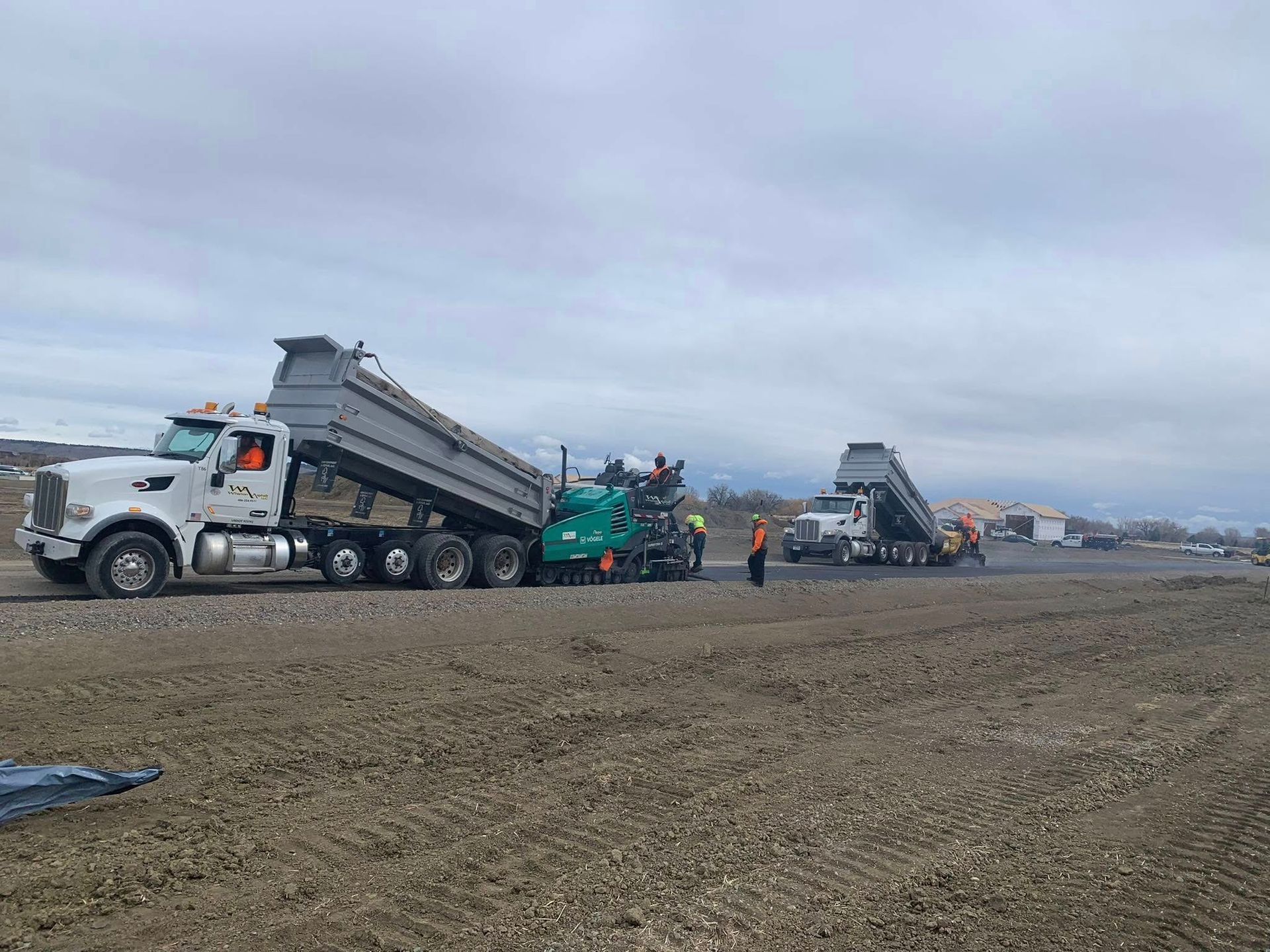 A dump truck is driving down a dirt road.