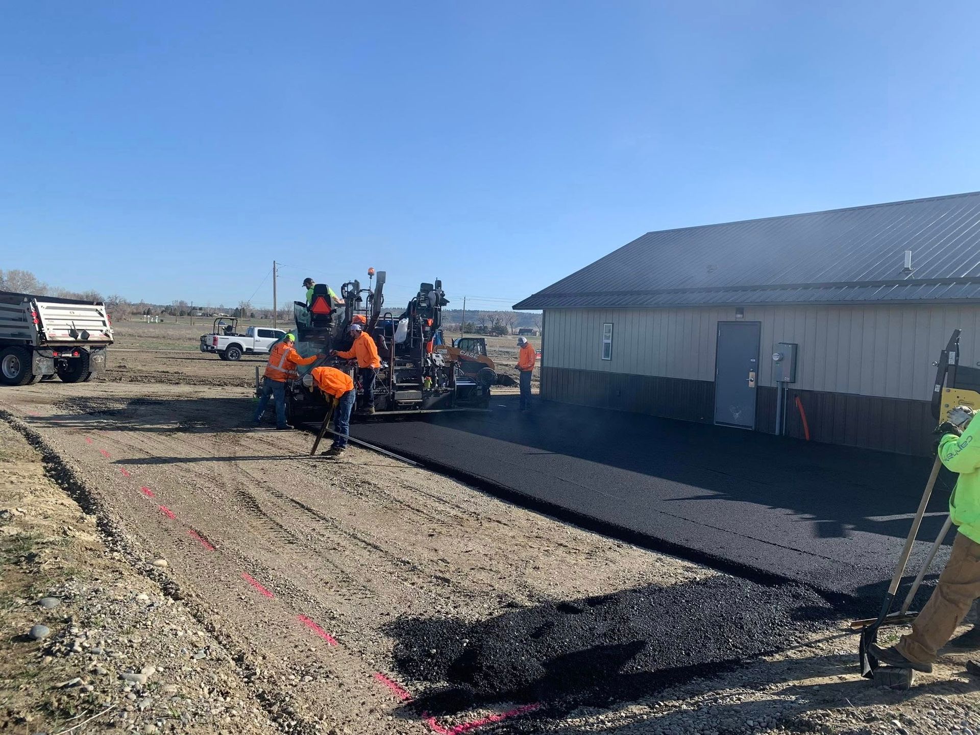 A group of people are working on a road in front of a building.