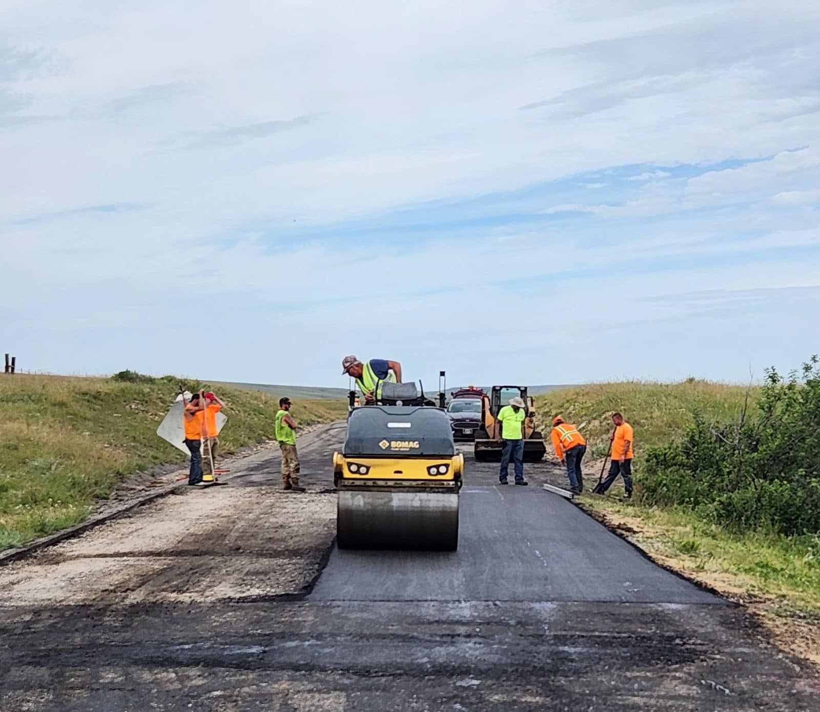A group of construction workers are working on a road.