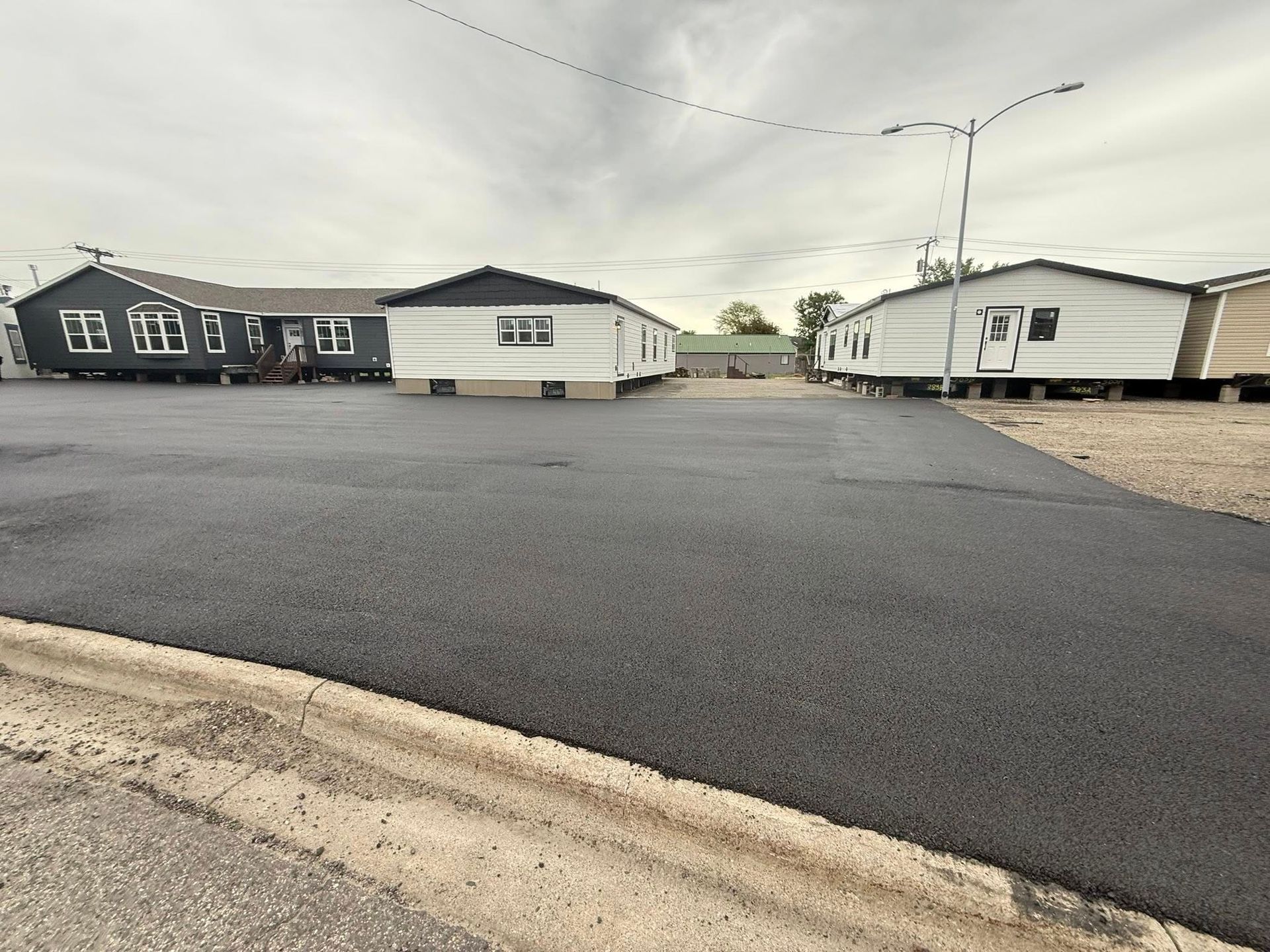 A row of mobile homes are parked in a parking lot.