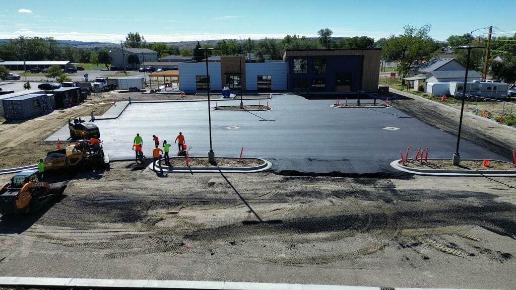 An aerial view of a construction site with a building in the background.
