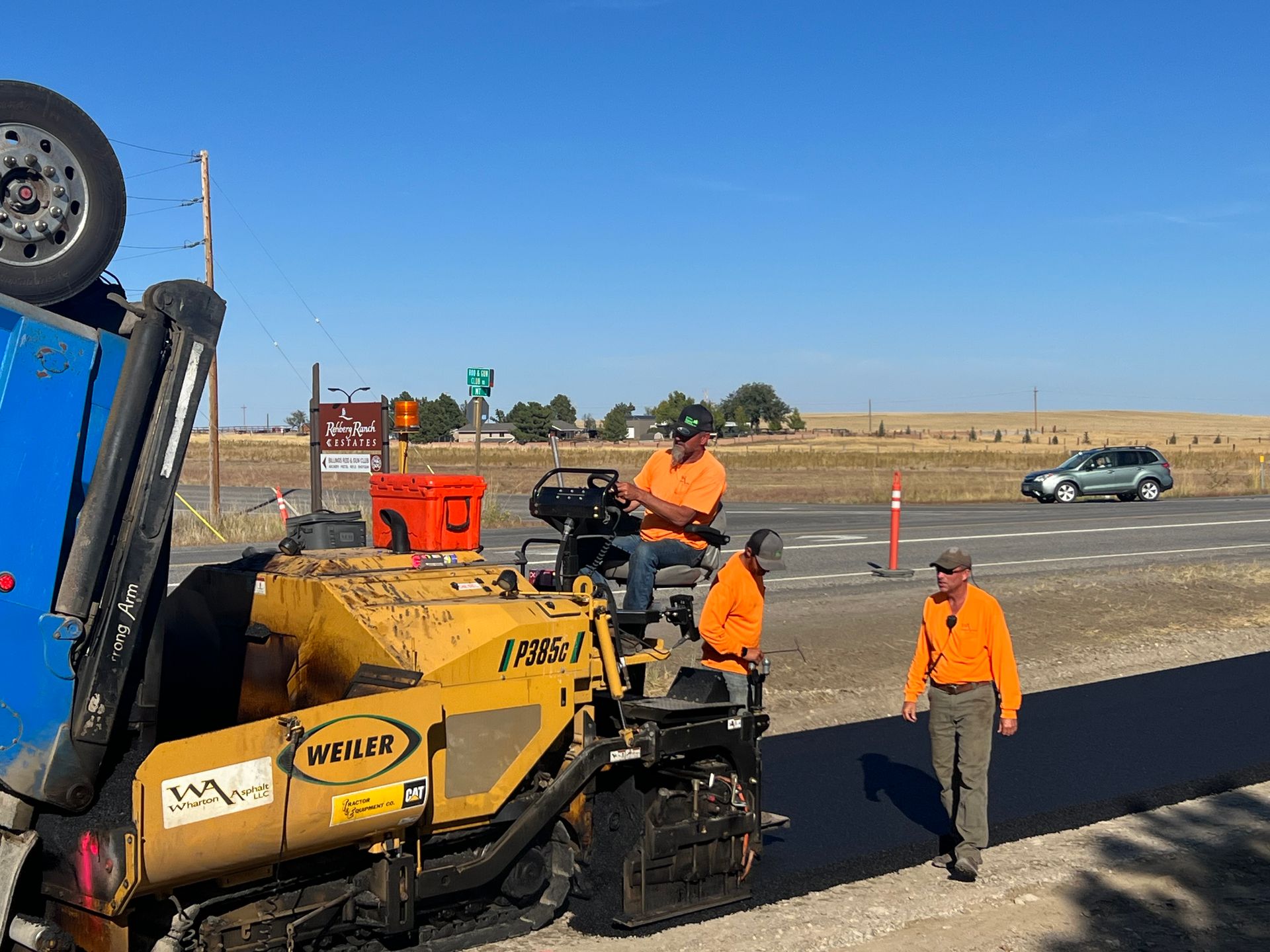 A group of construction workers are working on a road.