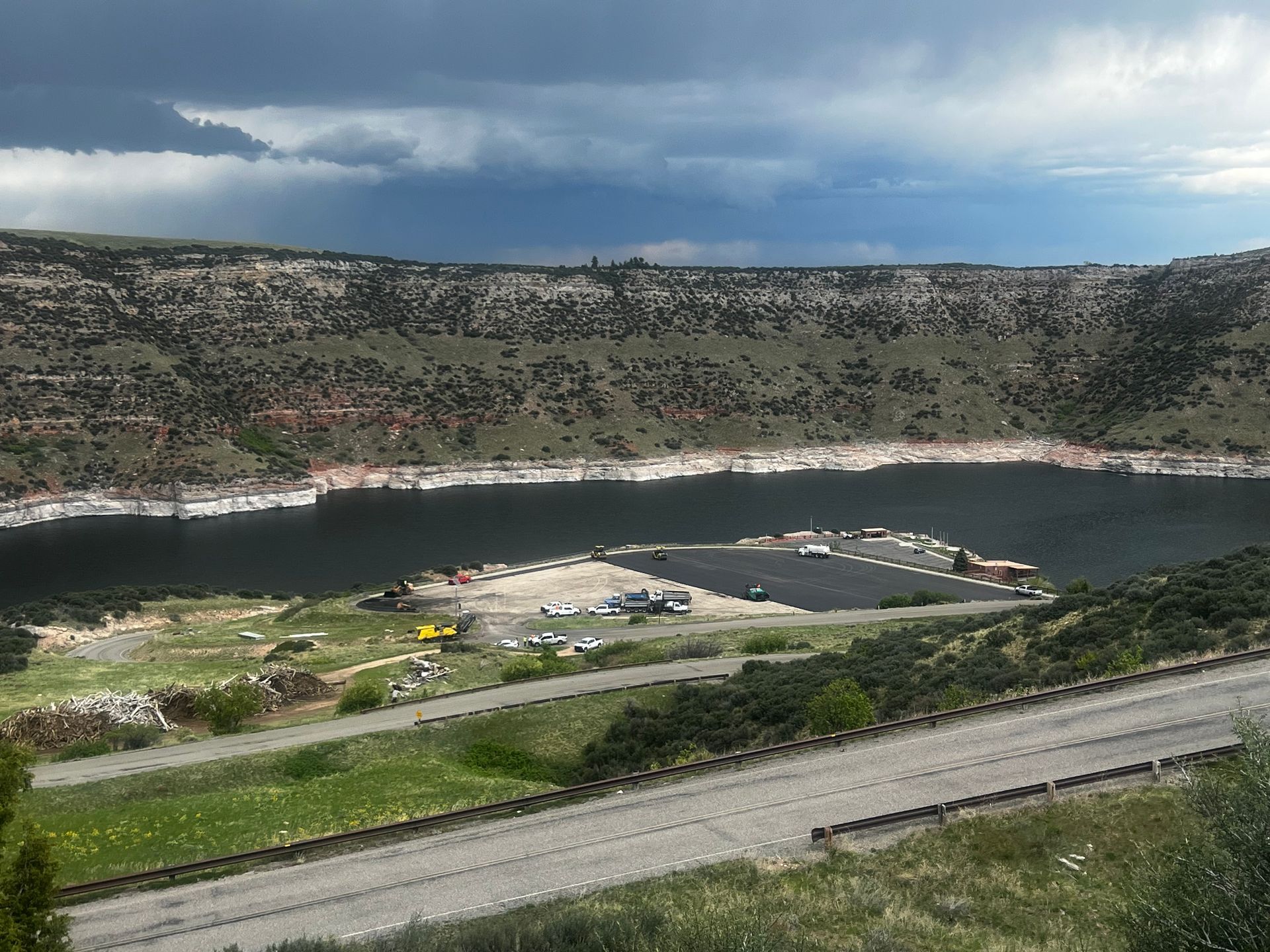 A large body of water surrounded by mountains and a road