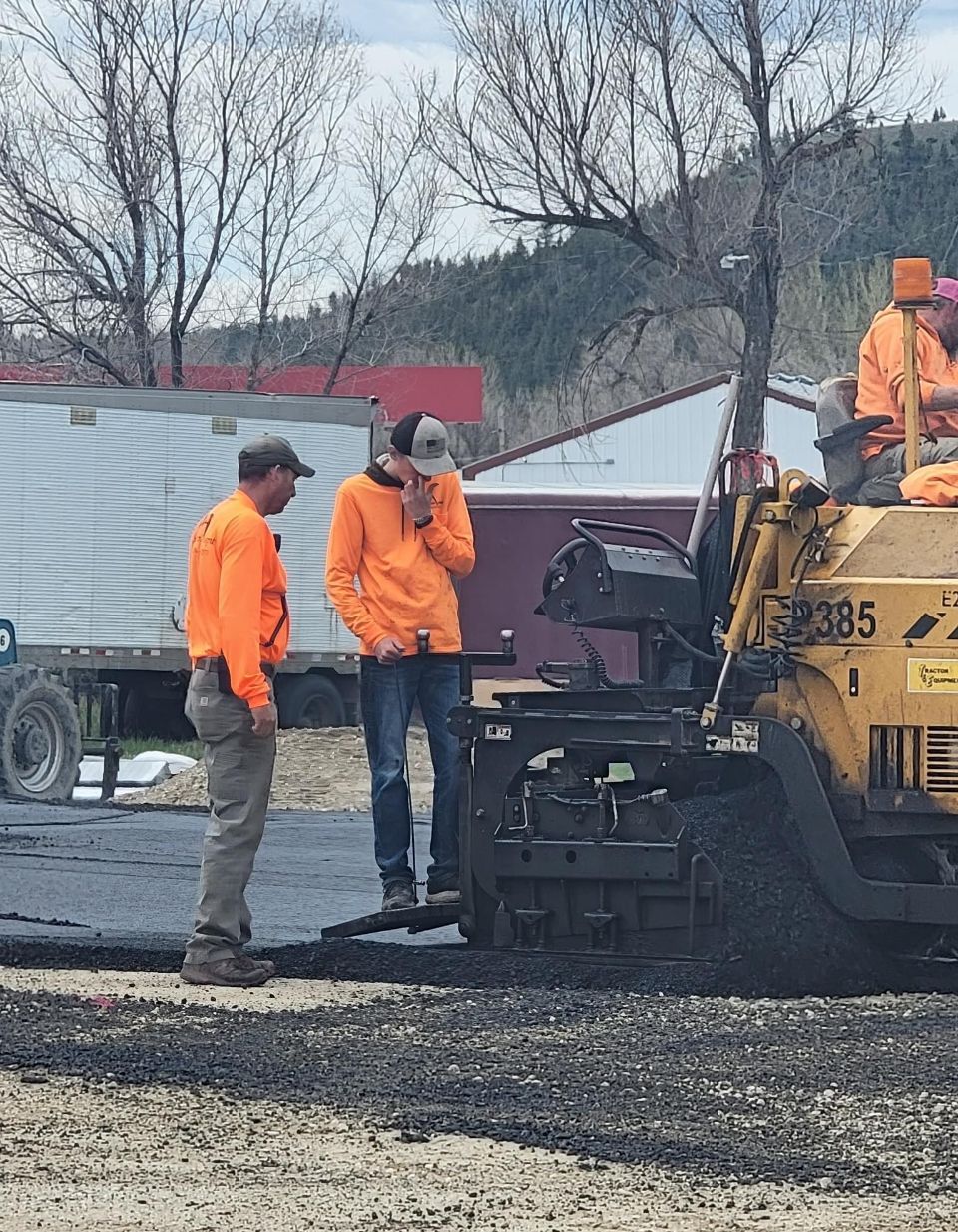 A group of construction workers are working on a road.