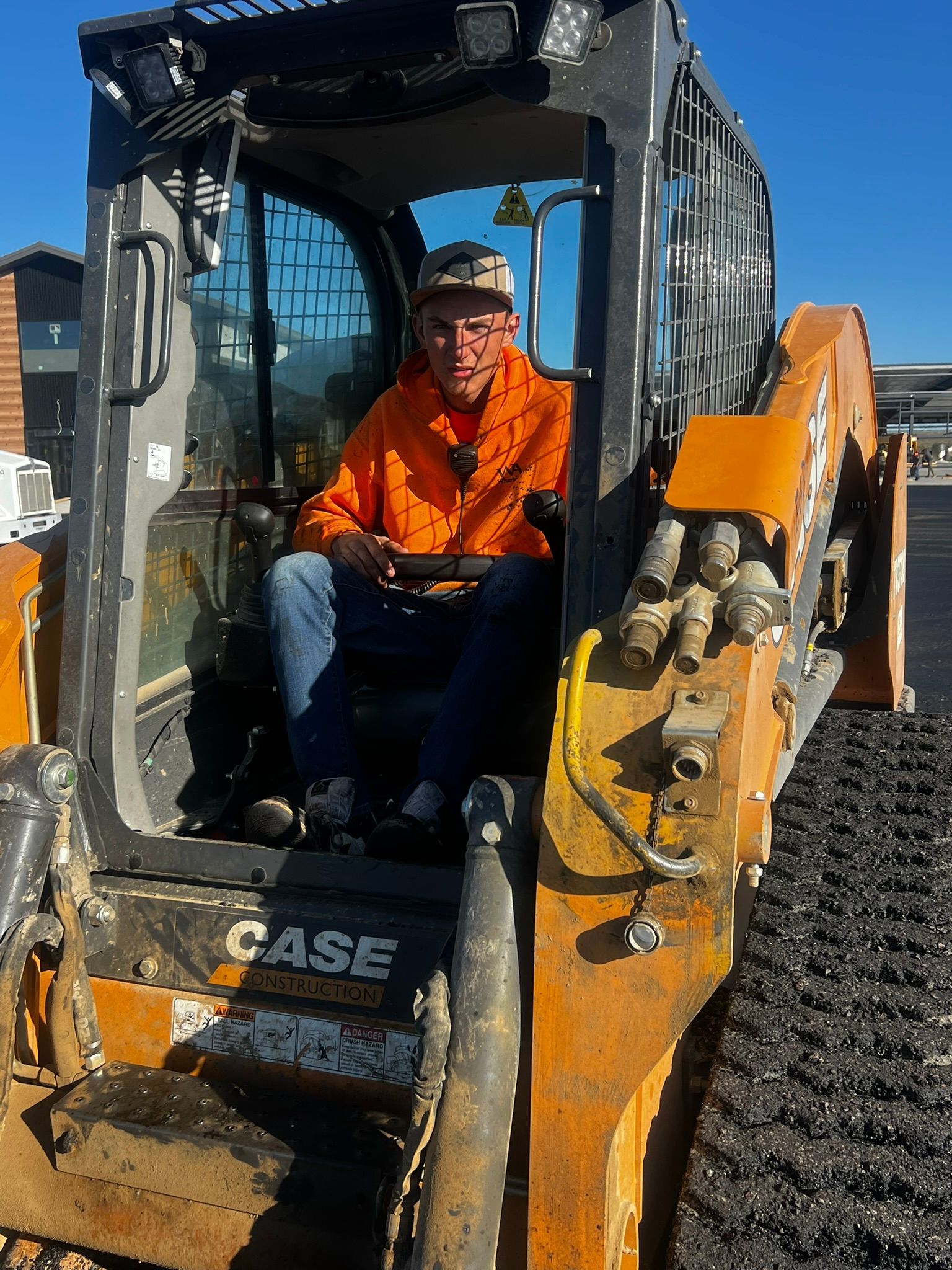 A man is sitting in the driver 's seat of a case bulldozer.
