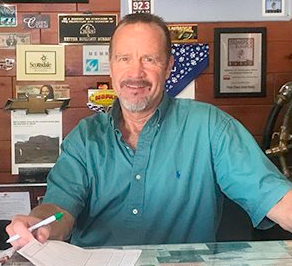 A man is sitting at a desk with a pen in his hand.