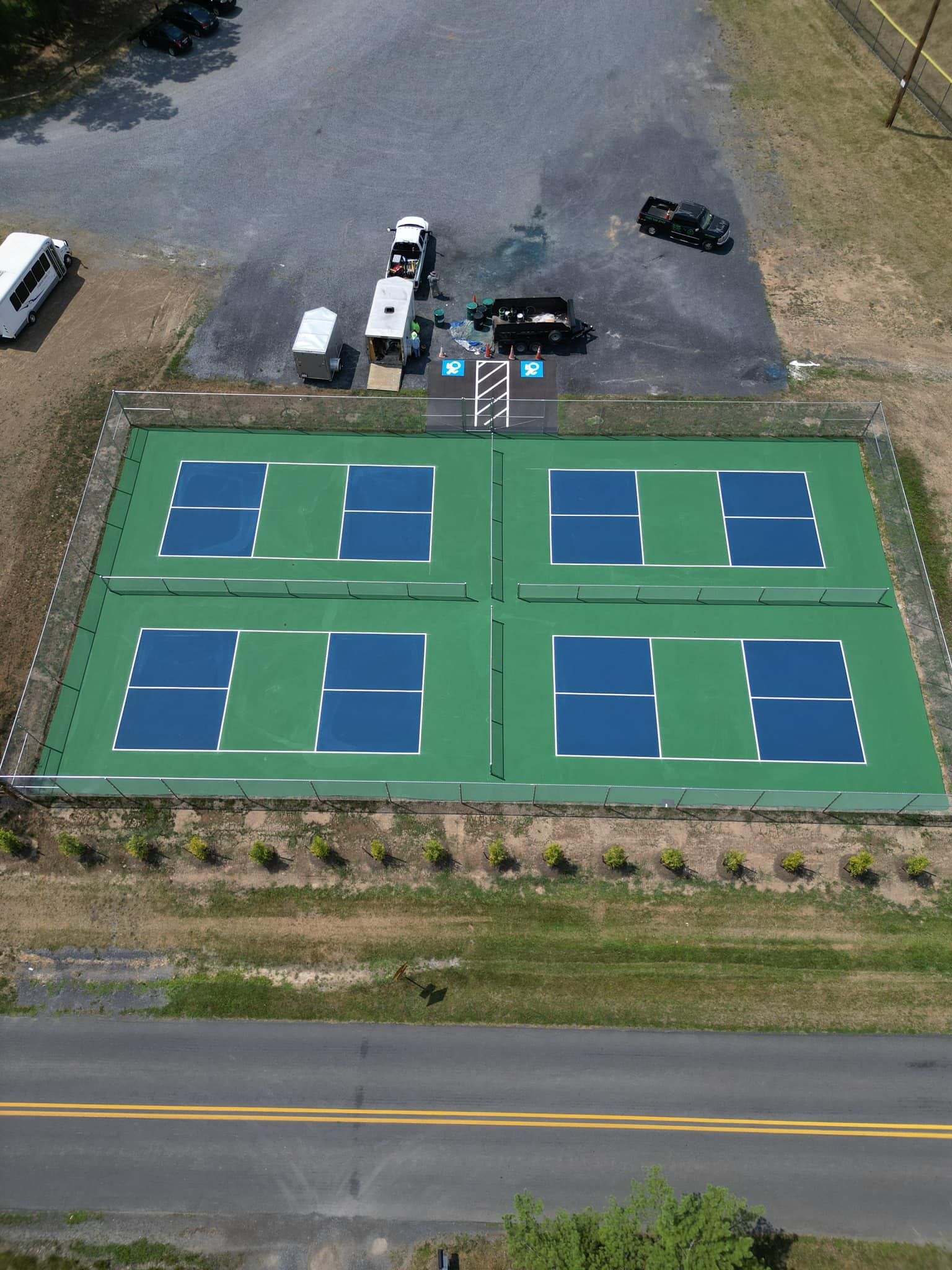 Image of a tennis court that just got their lines striped. 