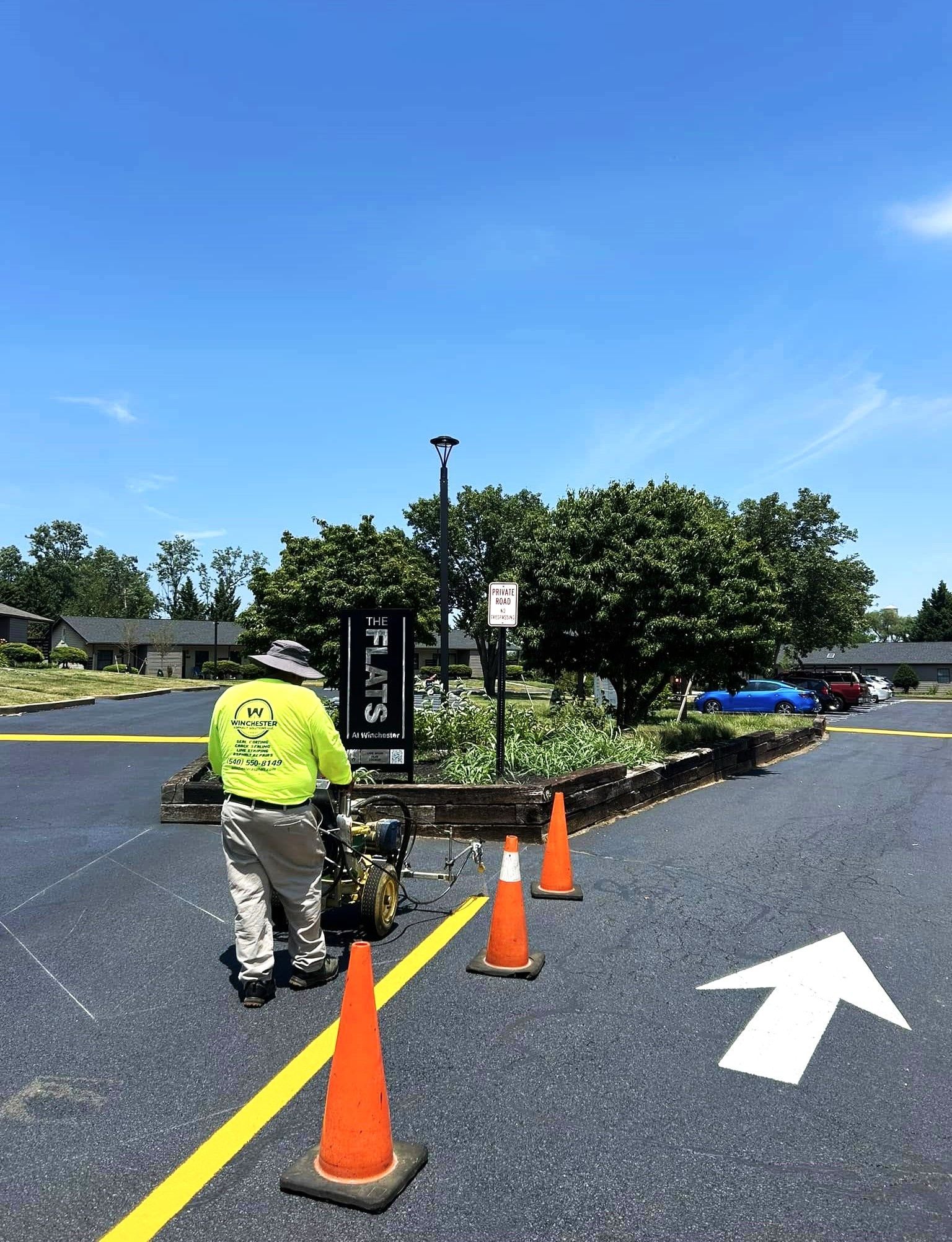 Image of a person painting the yellow lines in a parking lot.