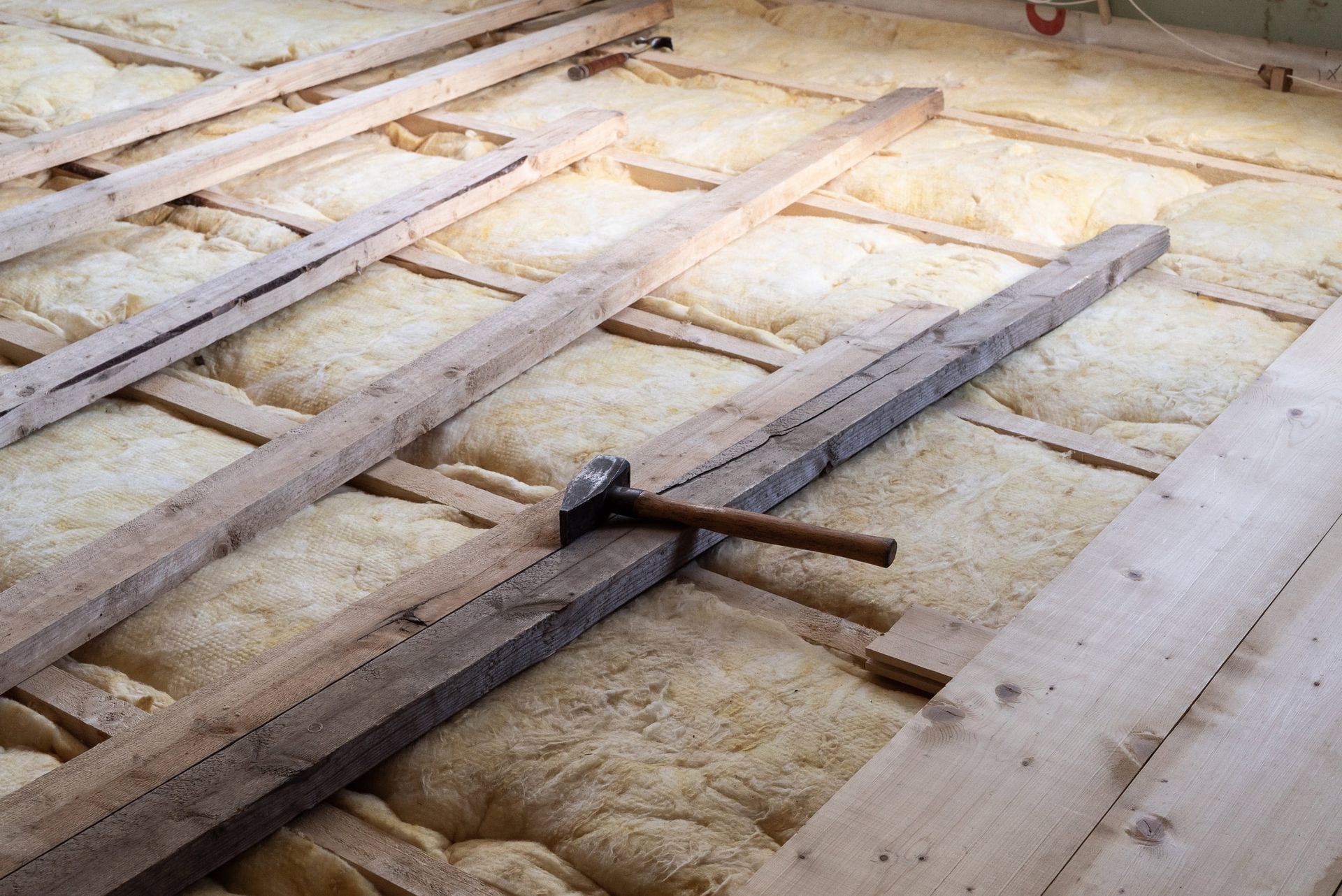 Warm Insulation With Carpenter Hammer for Home Floor — New Richmond, WI — Spray Foam Technologies LLC