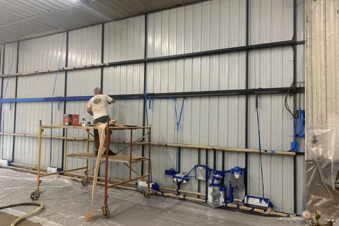 Man is Spraying a Wall in a Building — New Richmond, WI — Spray Foam Technologies LLC