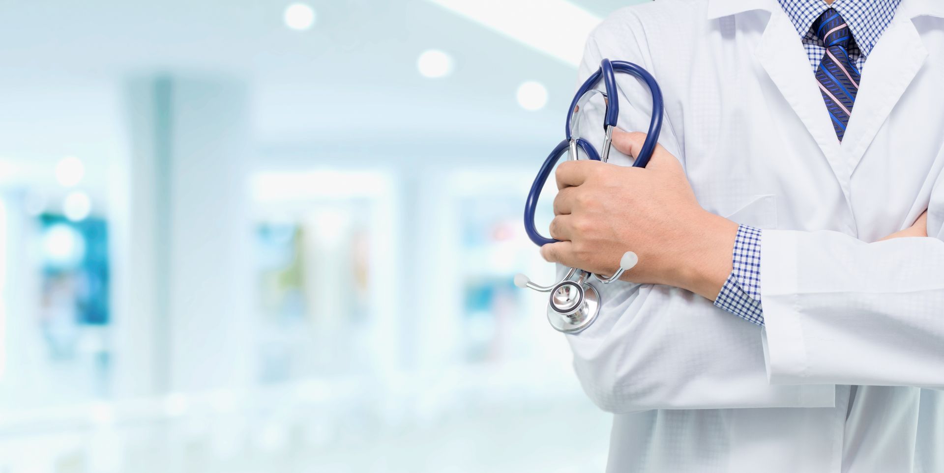 Doctor with a stethoscope in the hands behind the hospital background. Doctor with a stethoscope in the hands behind the hospital background.