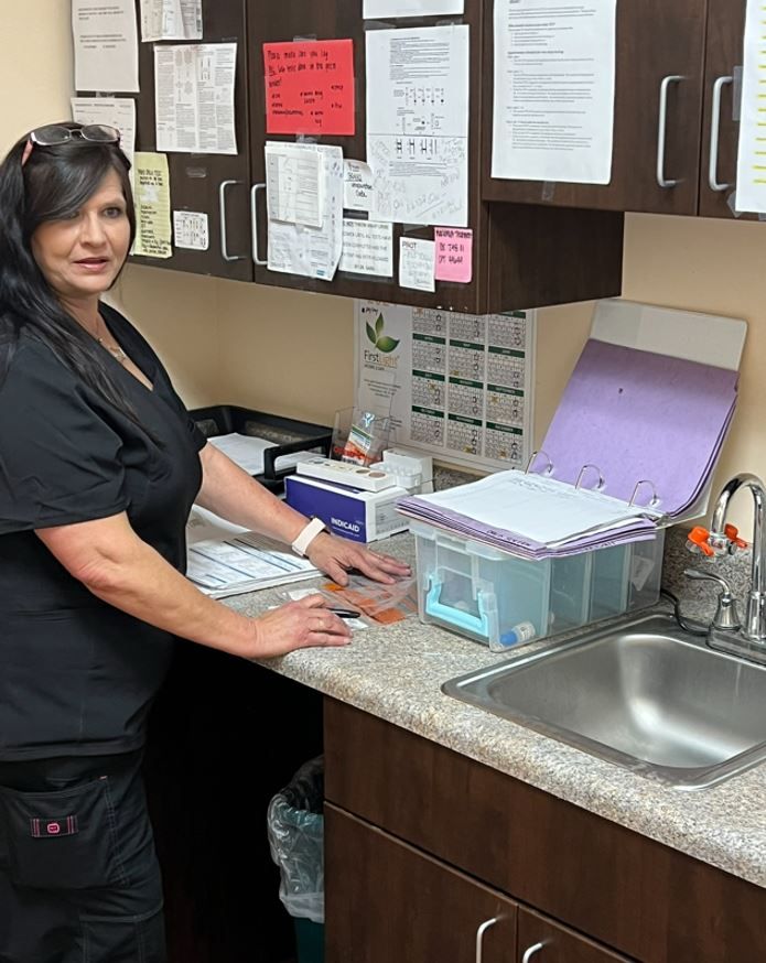 A woman is standing in a kitchen near a sink — Hampstead, NC  — Hampstead Medical Center PC