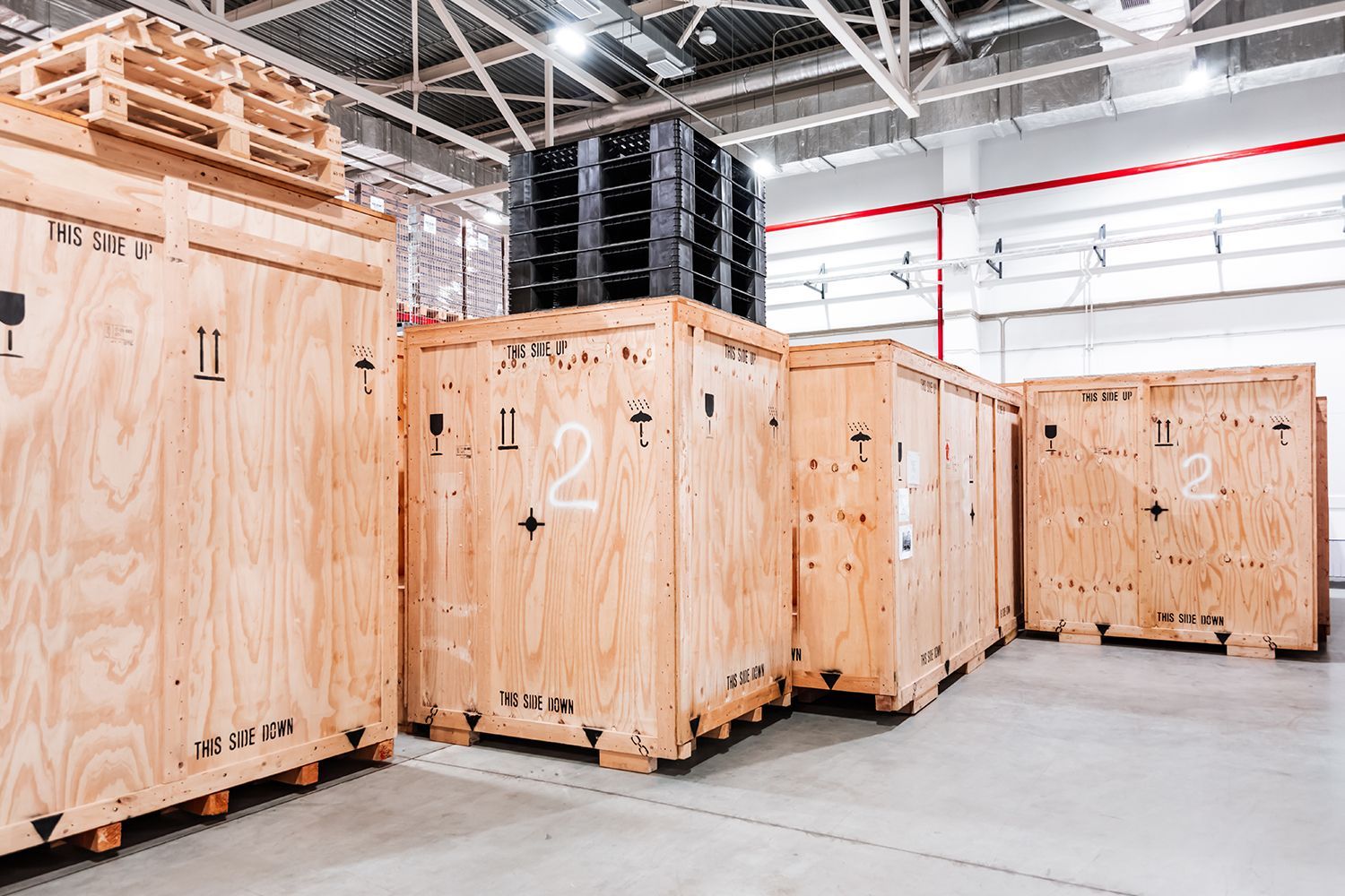 Custom wooden crates stacked in a warehouse, ready for shipping industrial equipment. Custom wooden crates stacked in a warehouse, ready for shipping industrial equipment.