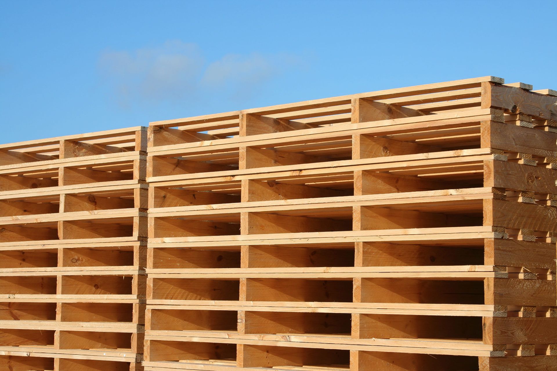 A semi truck with a trailer full of wooden pallets