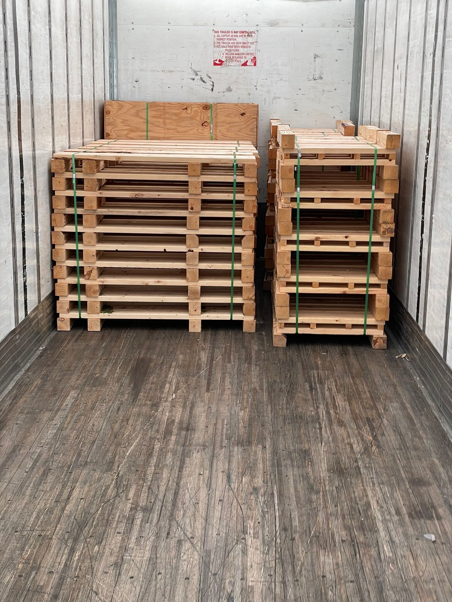 Two stacks of wooden pallets are sitting in the back of a truck.