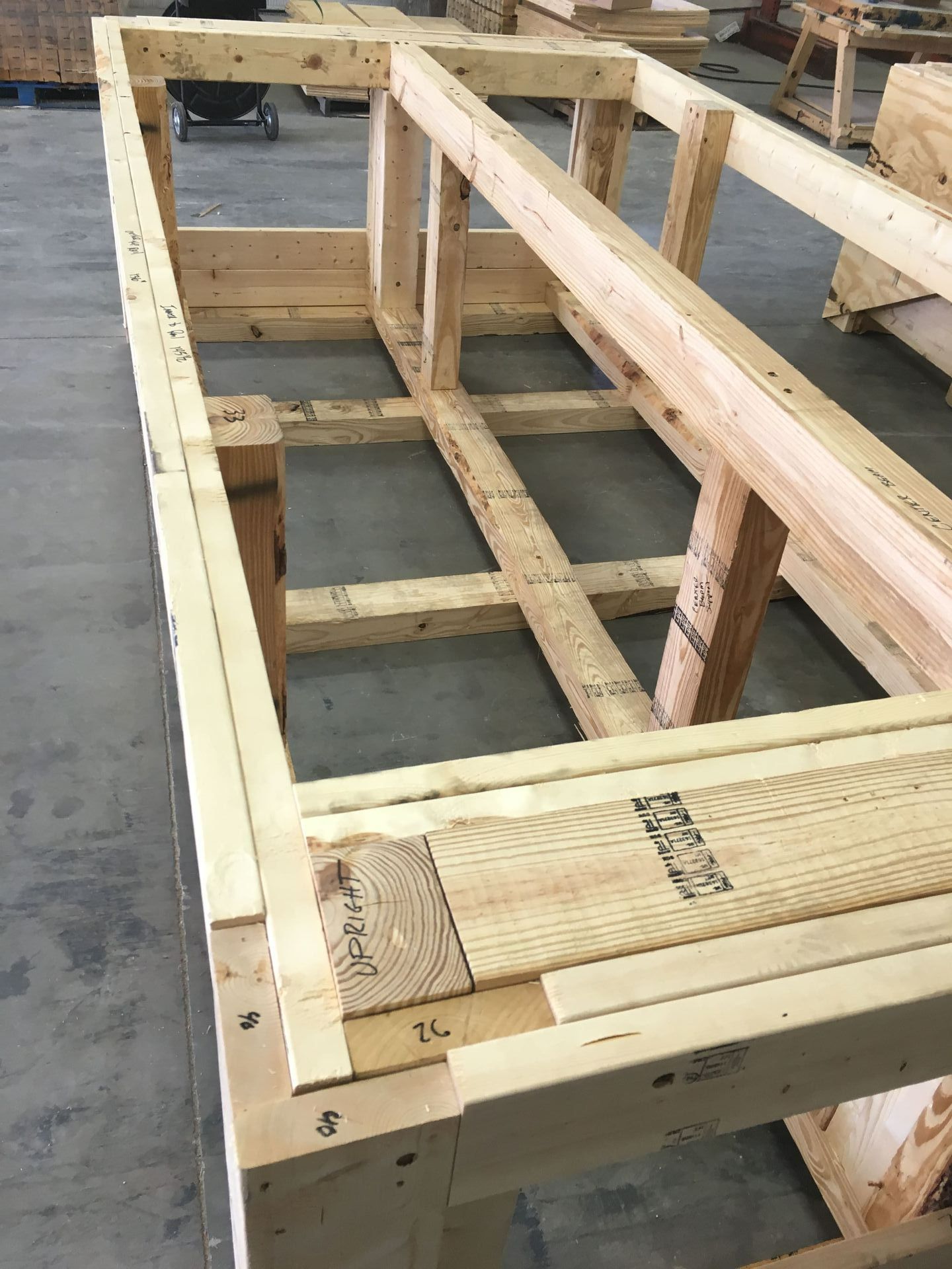 A large wooden crate is sitting on top of a concrete floor.