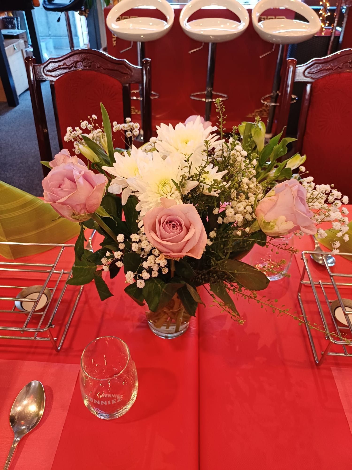 Ein Tisch mit einer Vase mit Blumen darauf.