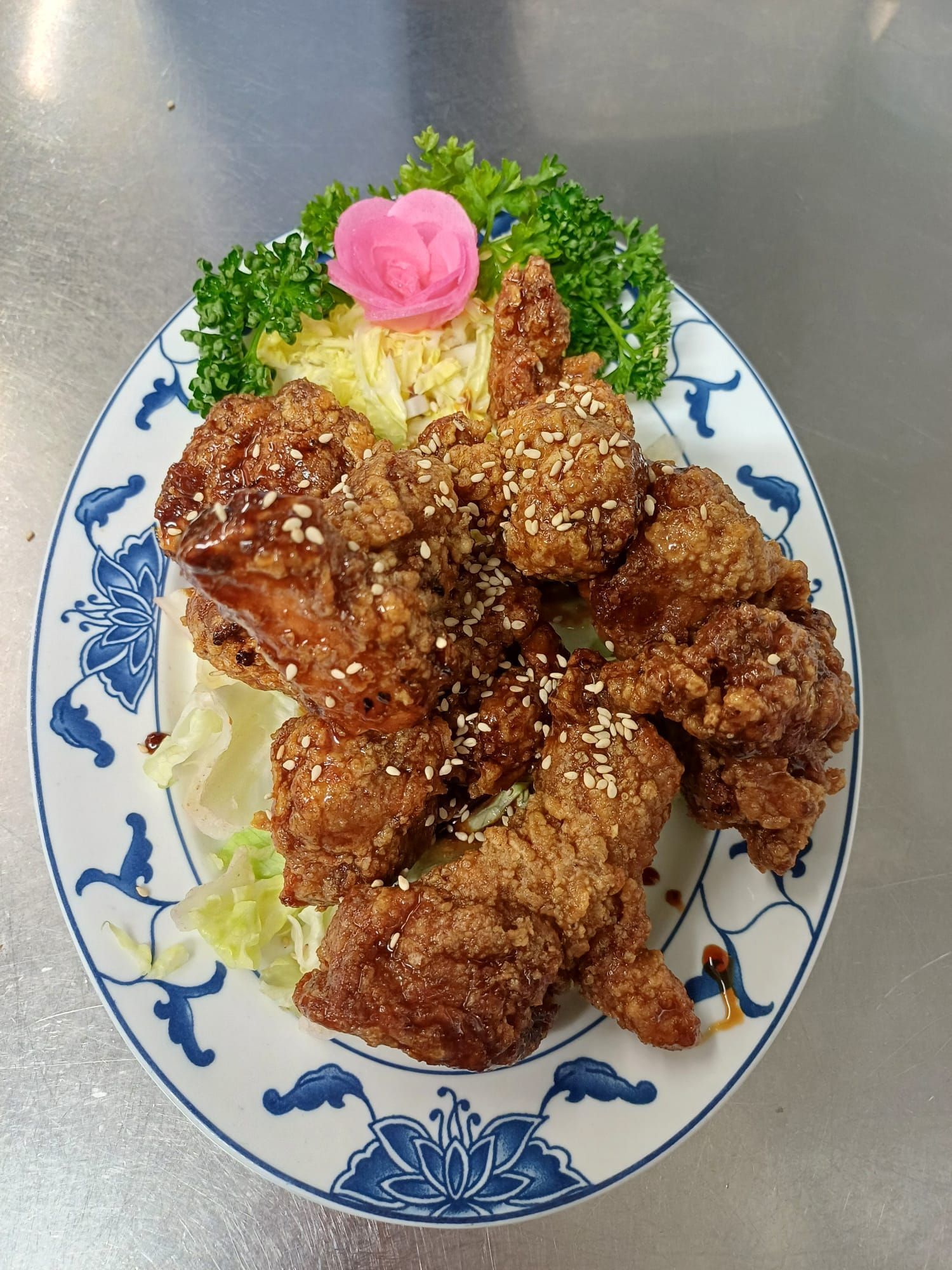 Eine Schüssel Nudeln mit Gemüse und Essstäbchen auf einem Holztisch.