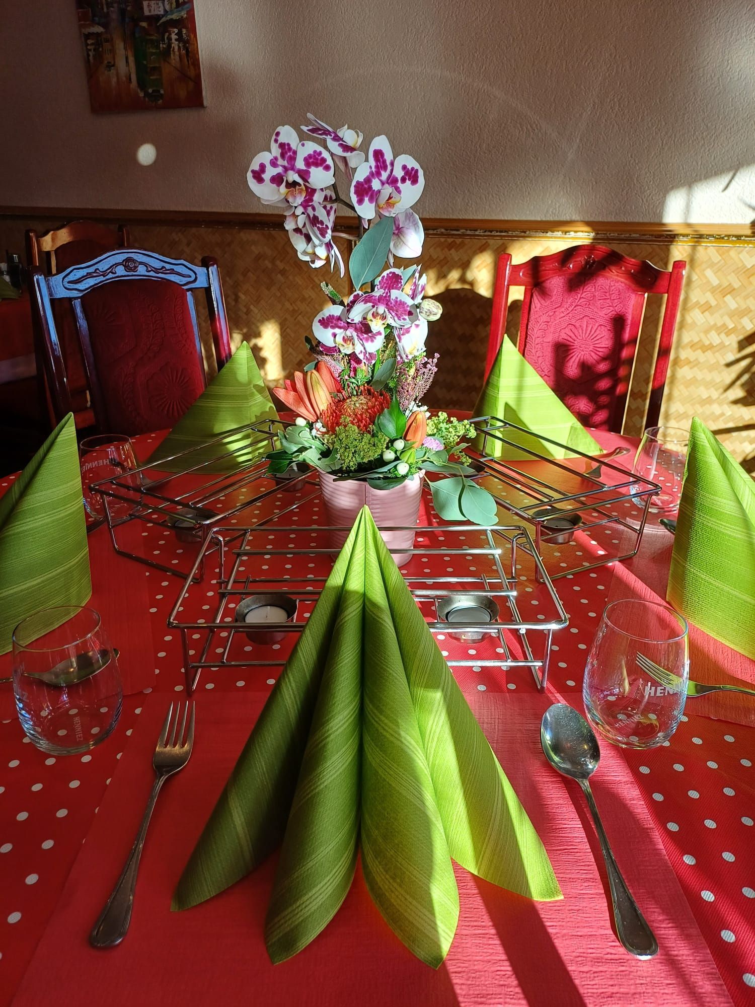 Ein Tisch mit grünen Servietten und Blumen darauf