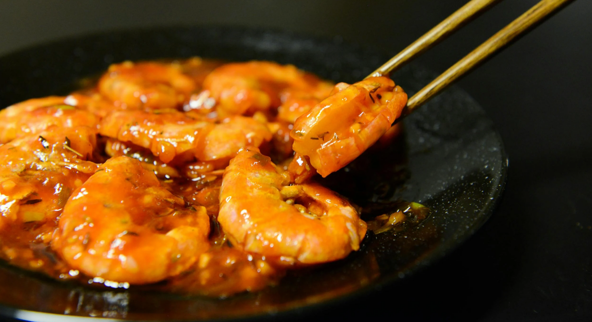 Eine Nahaufnahme eines Tellers mit Garnelen und Stäbchen.