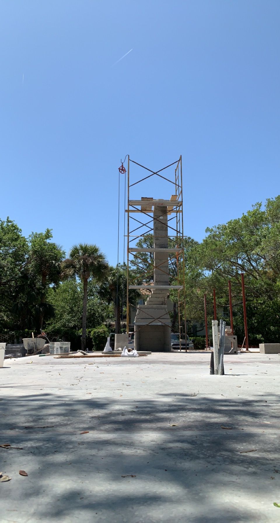 A large tower is being built in the middle of a park.