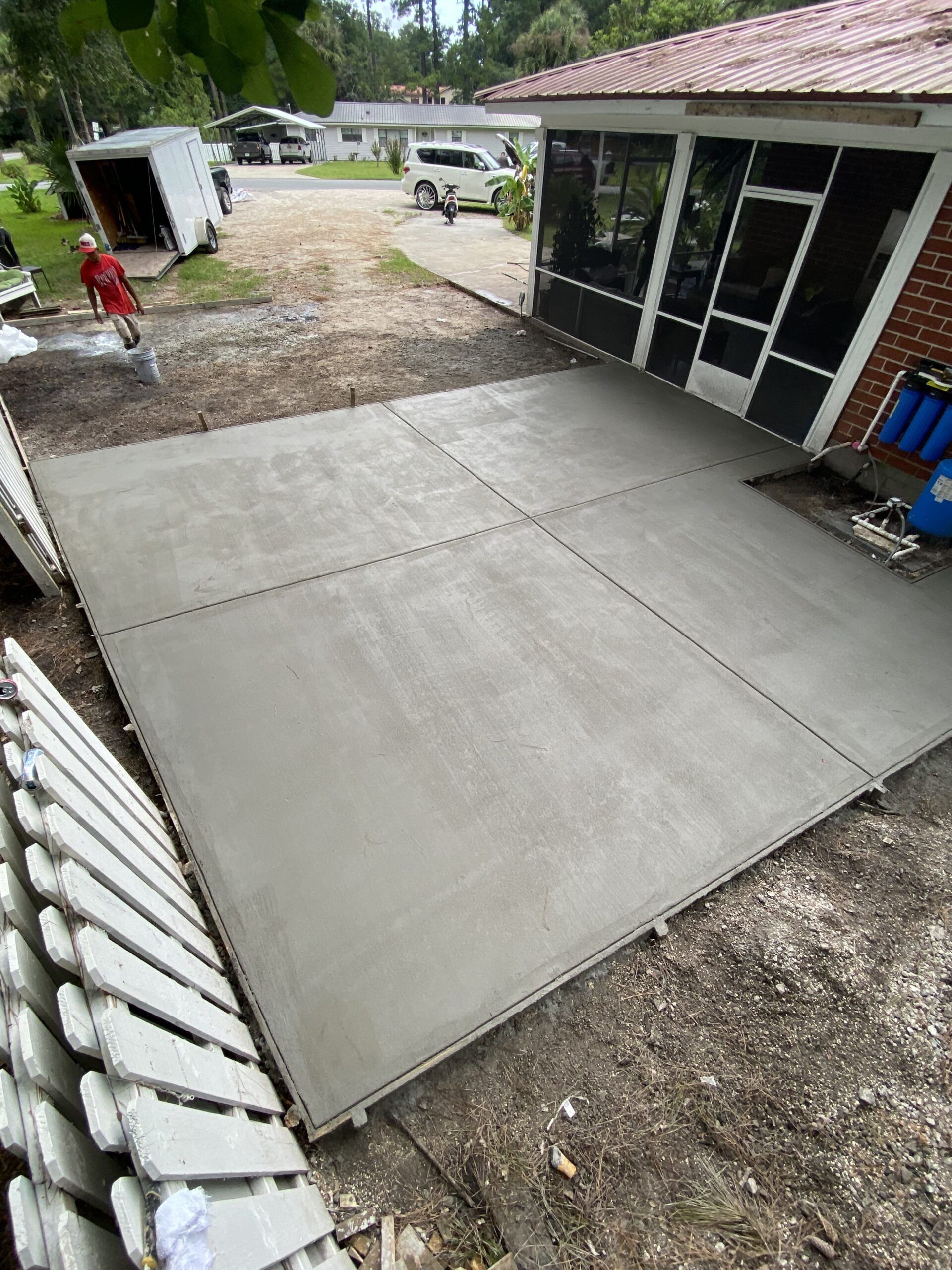A concrete driveway is being built in front of a house.