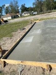 A concrete slab is being built in a yard with a wooden frame.