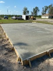 A large concrete slab is sitting on top of a dirt field.